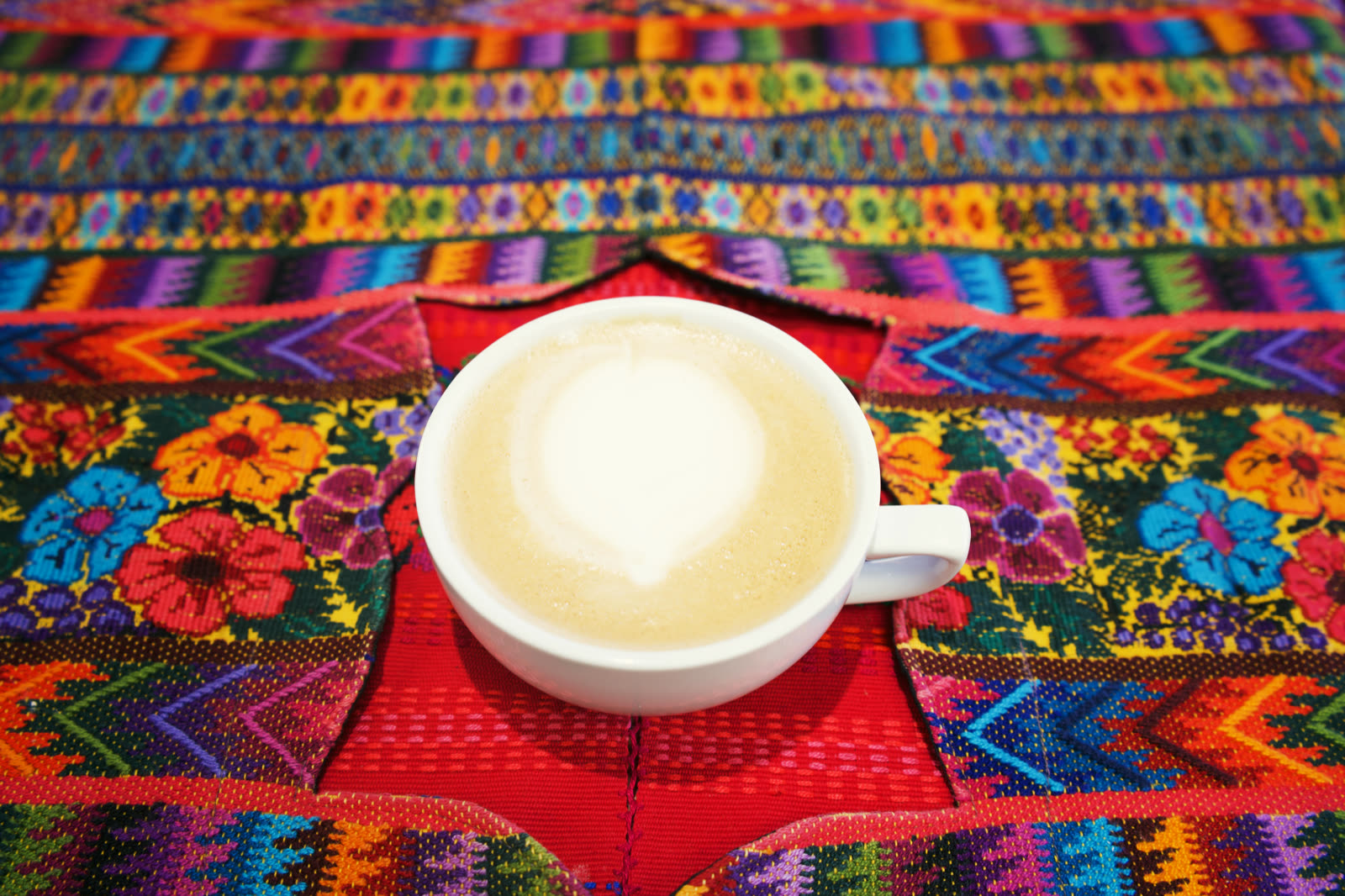 Latte with latte art on a Guatemalan woven tablecloth